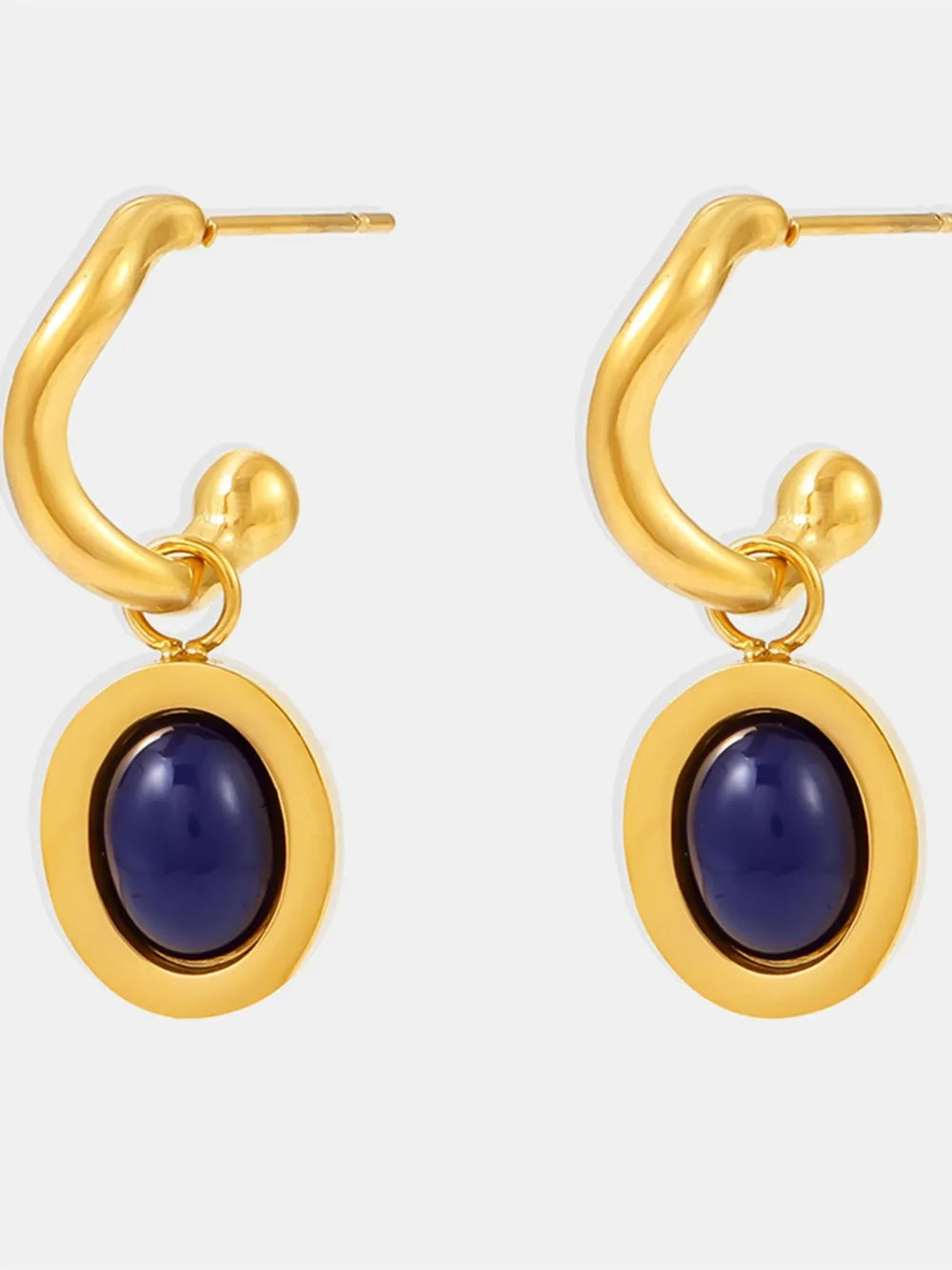 Sculptural hoop earrings with inset oval blue stone, gold tone metal.