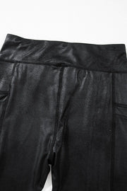 Black faux leather leggings with textured finish and side pockets.