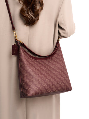 burgundy handbag featuring adjustable strap and geometric