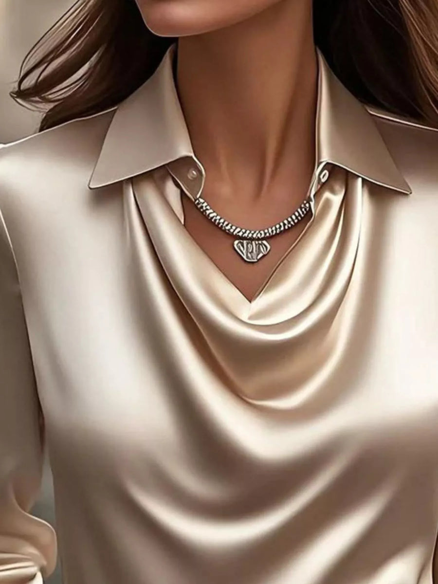 Tan satin cowl neck long-sleeve blouse with a collared neckline and draped front.