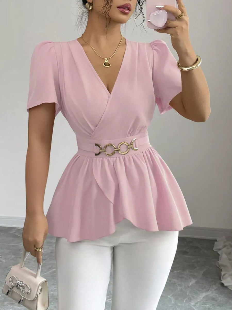 Pink polyester surplice blouse with belted waist and peplum hem.