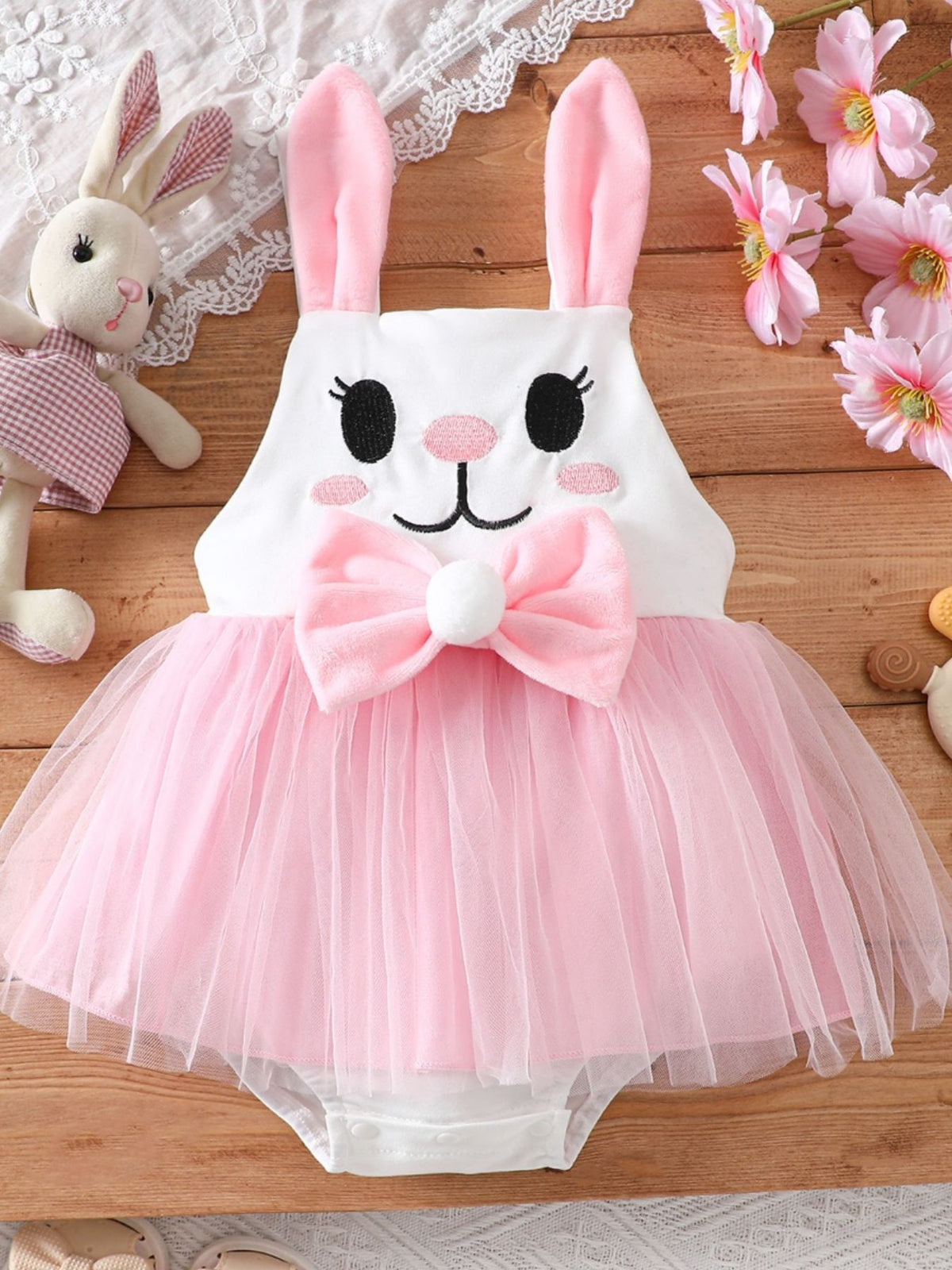 White bunny embroidered baby one-piece with pink tutu skirt and bow.