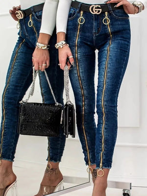 Dark blue skinny jeans with gold zipper details and raw hem.