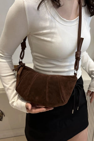 Brown suede crescent shoulder bag with pleated detail and knotted strap.