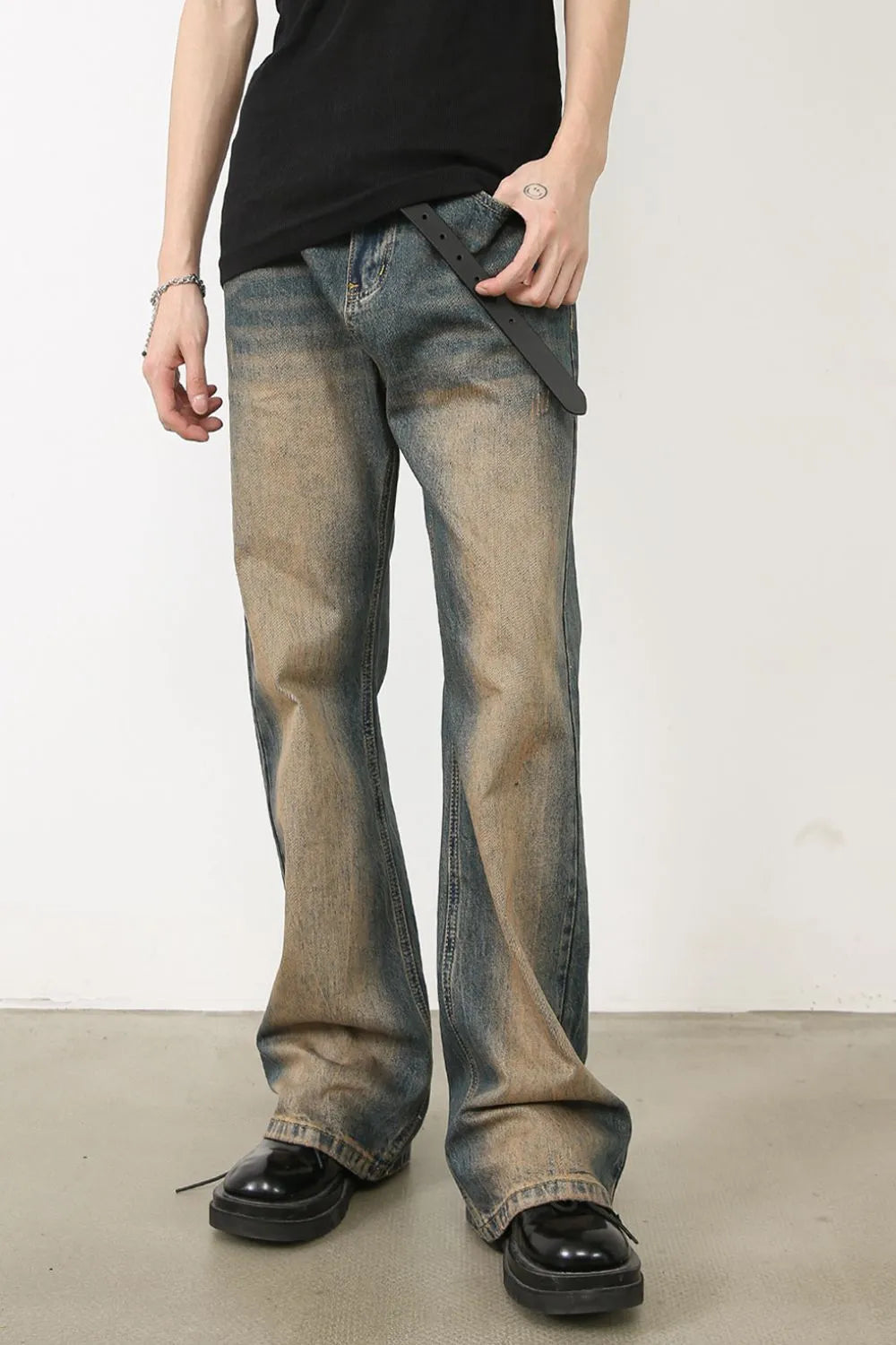 Faded wash bootcut denim jeans in medium with distressed detailing.