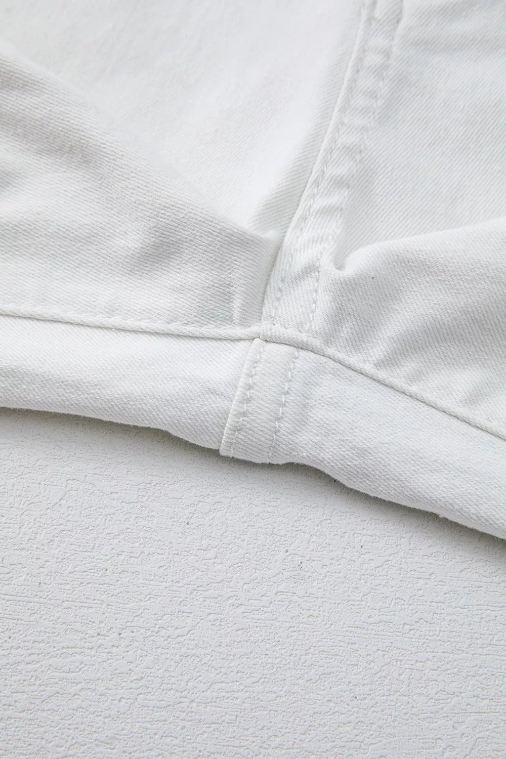 White denim jeans showing inseam and hem detail