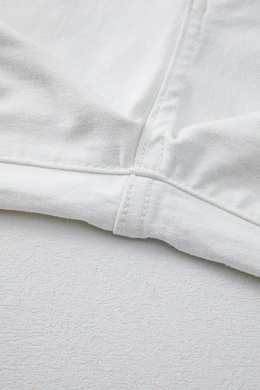 White denim jeans showing inseam and hem detail