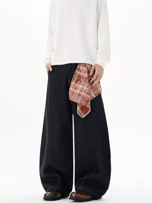 Black wide-leg jeans with plaid scarf detail and white long-sleeve shirt.