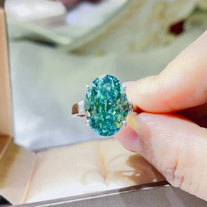 Emerald cut moissanite cocktail ring in turquoise with diamond accents on band.