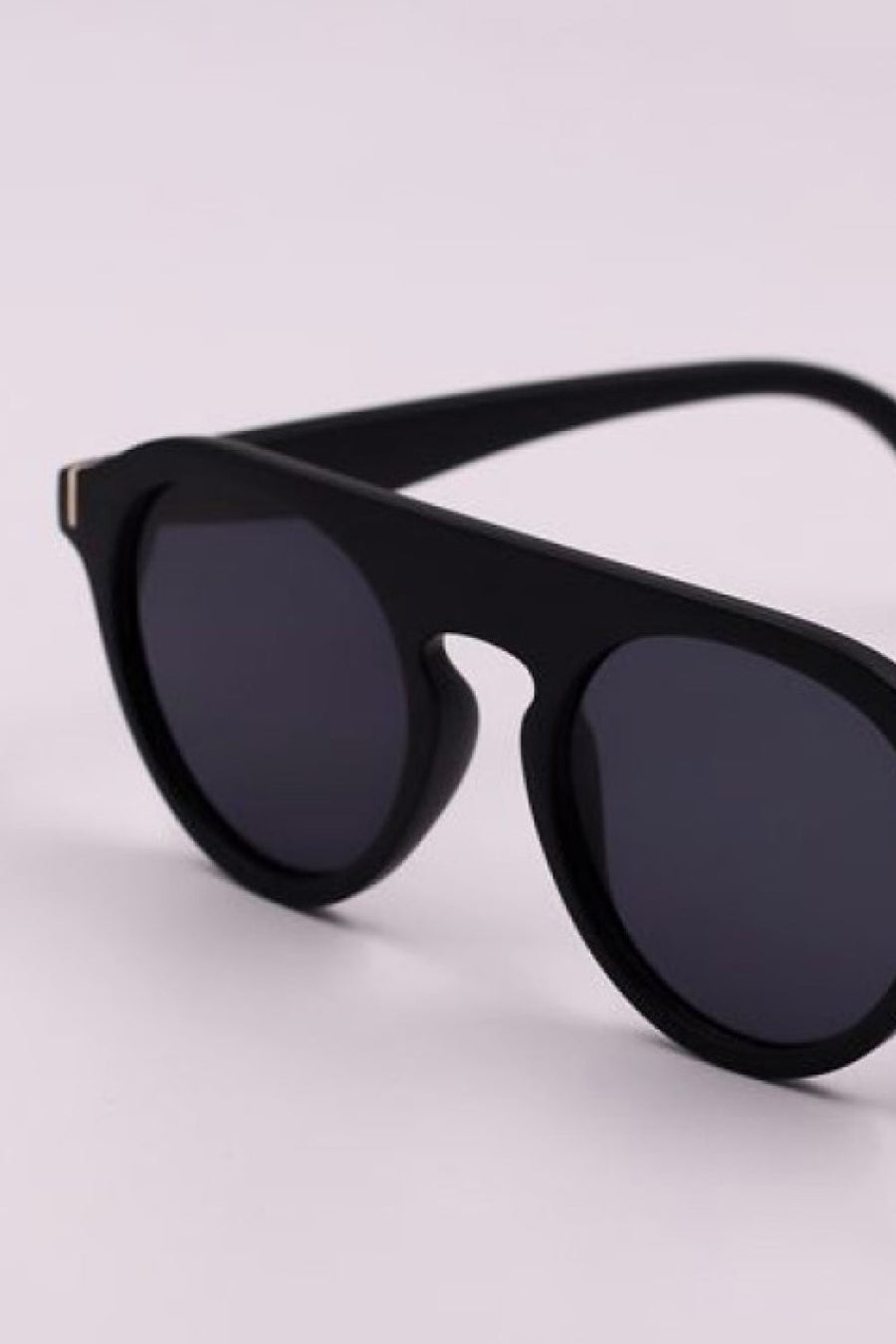 Black round frame sunglasses with dark lenses and gold accent detail