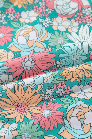Floral peplum blouse with scallop trim in a vibrant floral print.