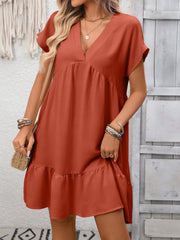 Rust red V-neck mini dress with short sleeves and a ruffled hem.