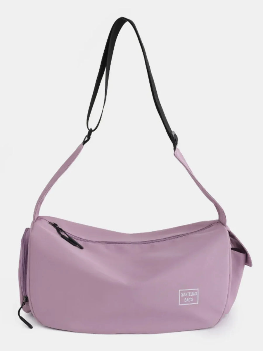 Slouchy crescent crossbody bag in Moonlit Mauve with adjustable strap and zippered pockets.