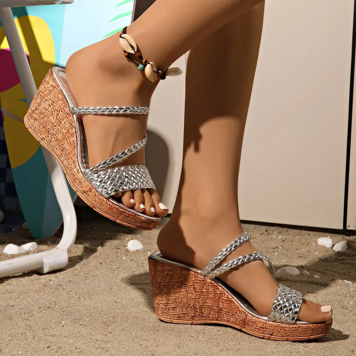 Silver woven metallic wedge sandals with cork-look platform and braided straps.