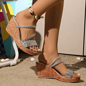 Silver woven metallic wedge sandals with cork-look platform and braided straps.