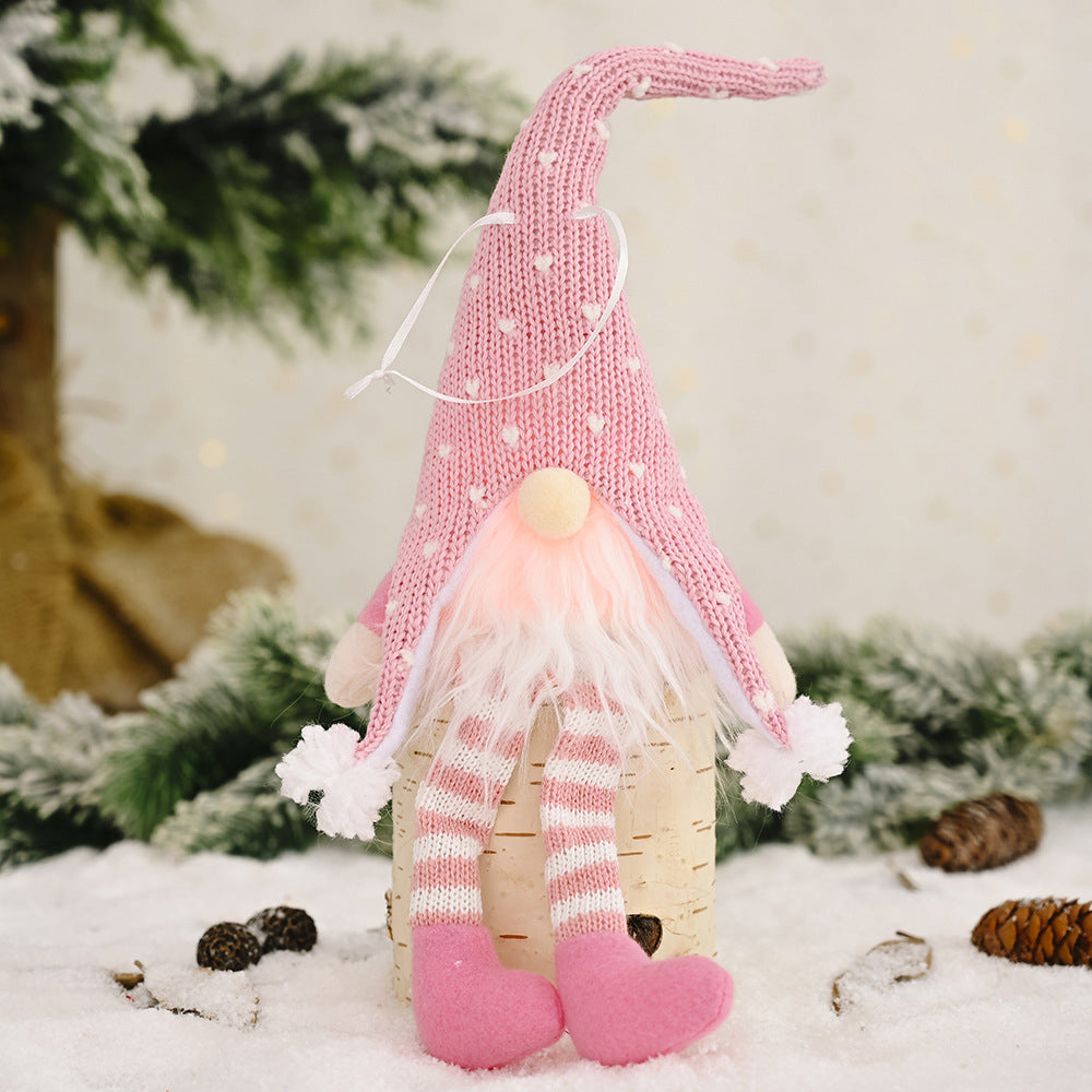 Blush pink knitted gnome ornament with white hearts, striped legs, and fluffy beard.