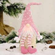 Blush pink knitted gnome ornament with white hearts, striped legs, and fluffy beard.