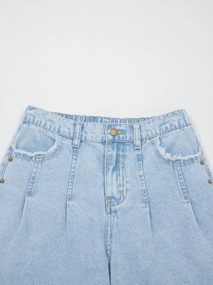 Light wash denim jeans with studded pockets and wide legs.