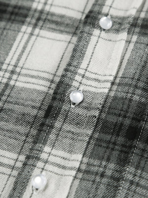 Button-up long sleeve shirt in black and white plaid cotton with pearl buttons.