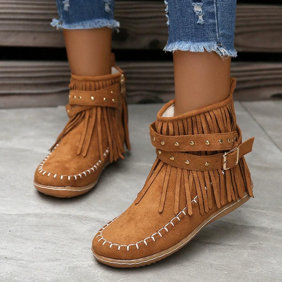 Caramel suede ankle boots with fringe, studs, and buckle detail.