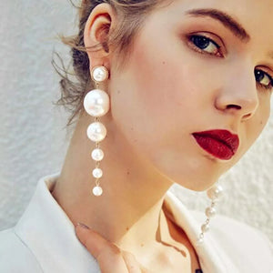 Elegant gold cascading pearl drop earrings with multiple pearl sizes.