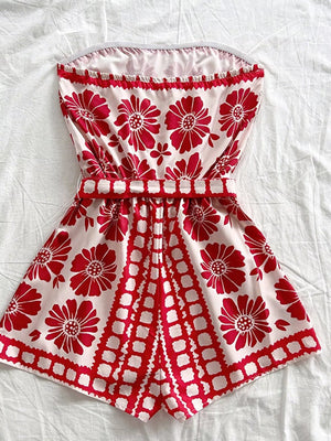Red floral tie-waist strapless maternity romper cover-up with ruffled neckline.