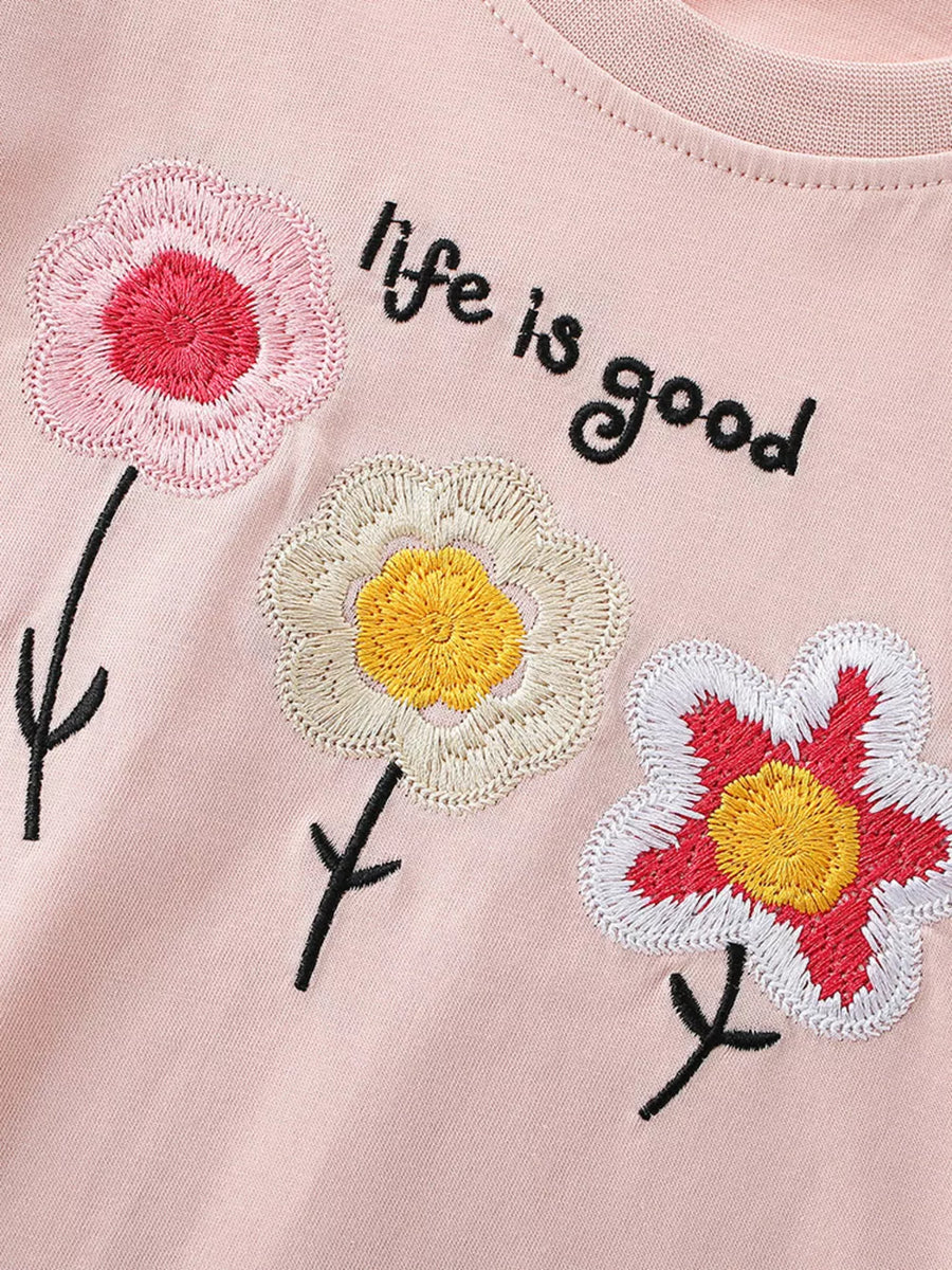Pink cotton t-shirt with embroidered floral detail and "life is good" text.