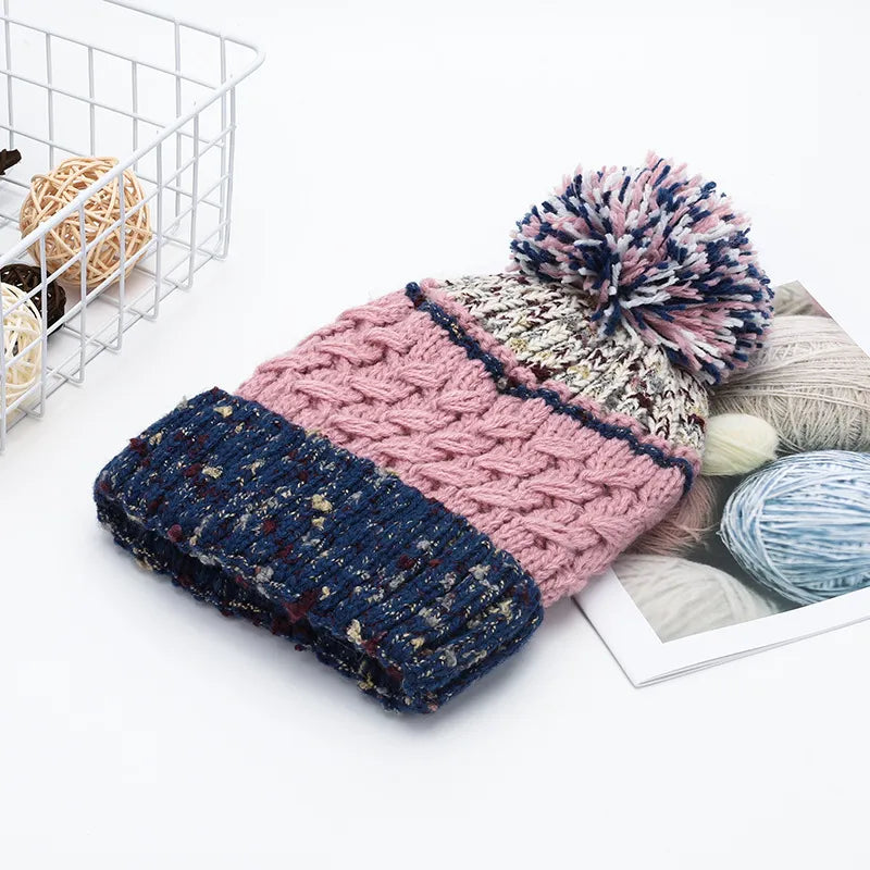 Textured cable knit beanie with pompom in pink and navy blue.