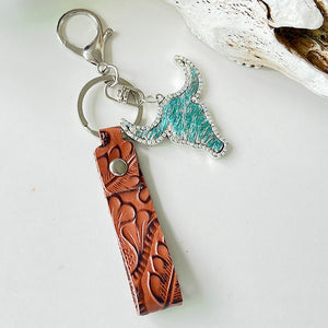 Western keychain with turquoise bull skull charm, rhinestones, and tooled leather strap.