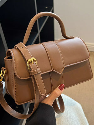 Chic small top handle bag in brown with gold buckle detail and adjustable strap.