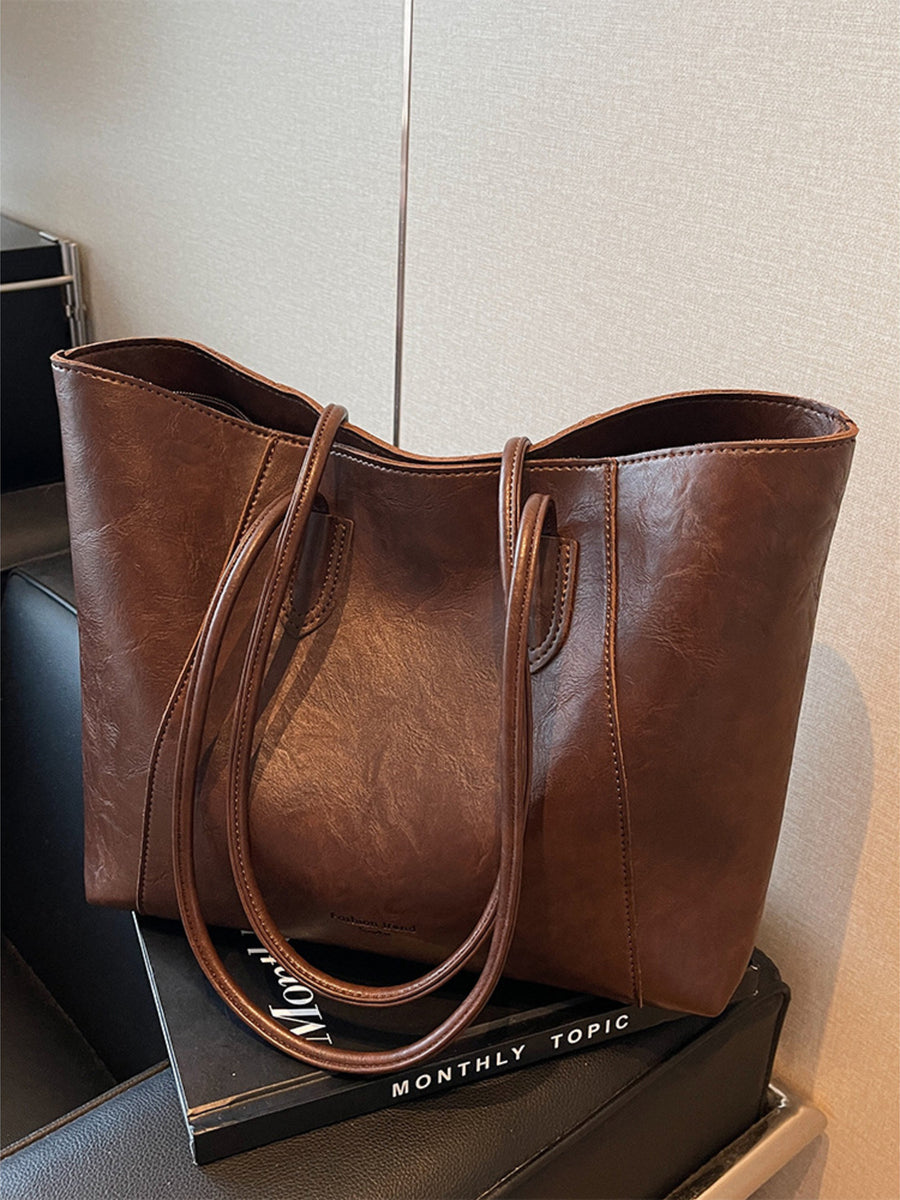 Brown crinkled PU leather tote bag with double straps and a spacious interior.