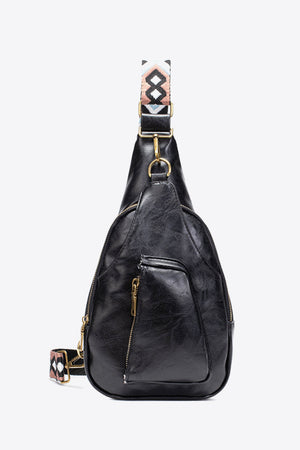 Black textured sling bag with woven geometric strap and gold hardware