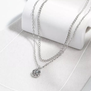 Silver double layered pendant necklace with a round crystal charm.