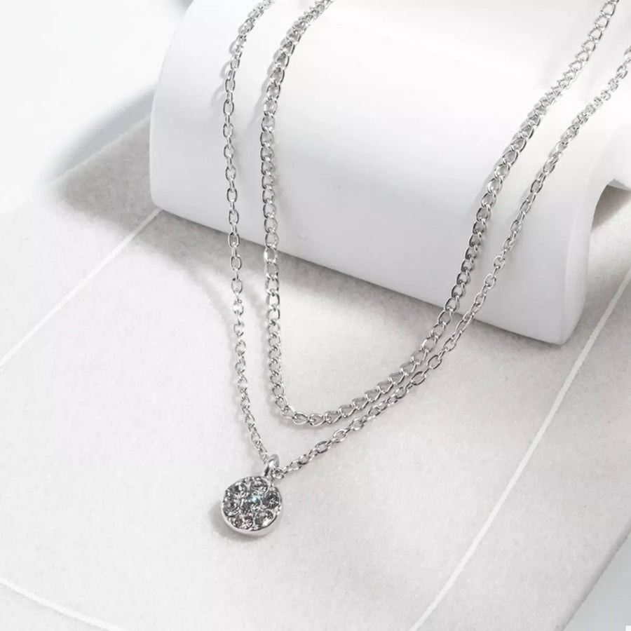 Silver double layered pendant necklace with a round crystal charm.