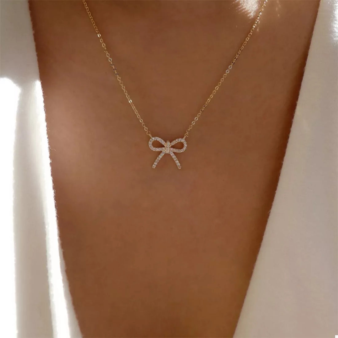 Gold bowknot pendant necklace with clear stones on a delicate chain