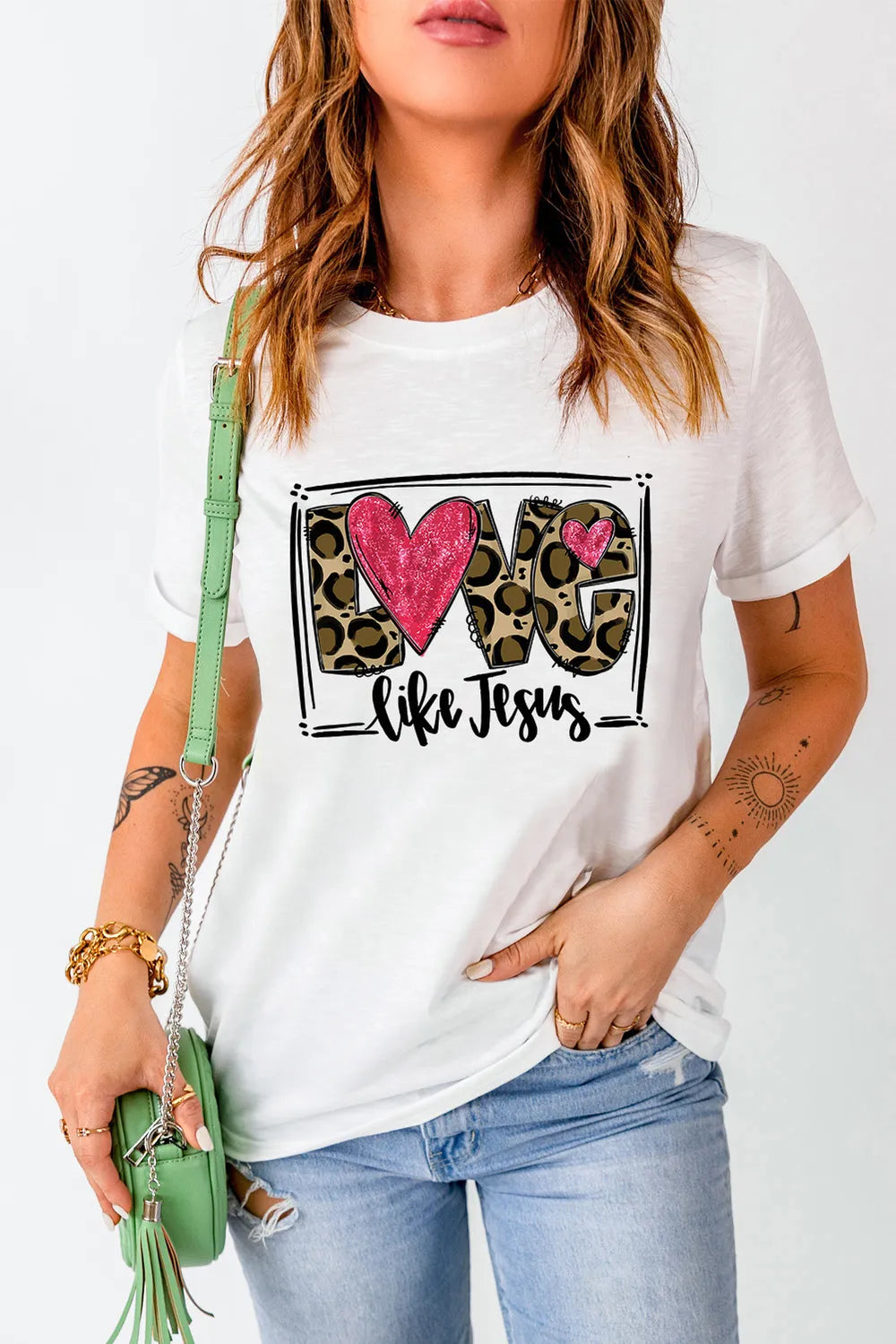 White graphic tee with leopard print "LOVE" and pink hearts, "like Jesus" text.