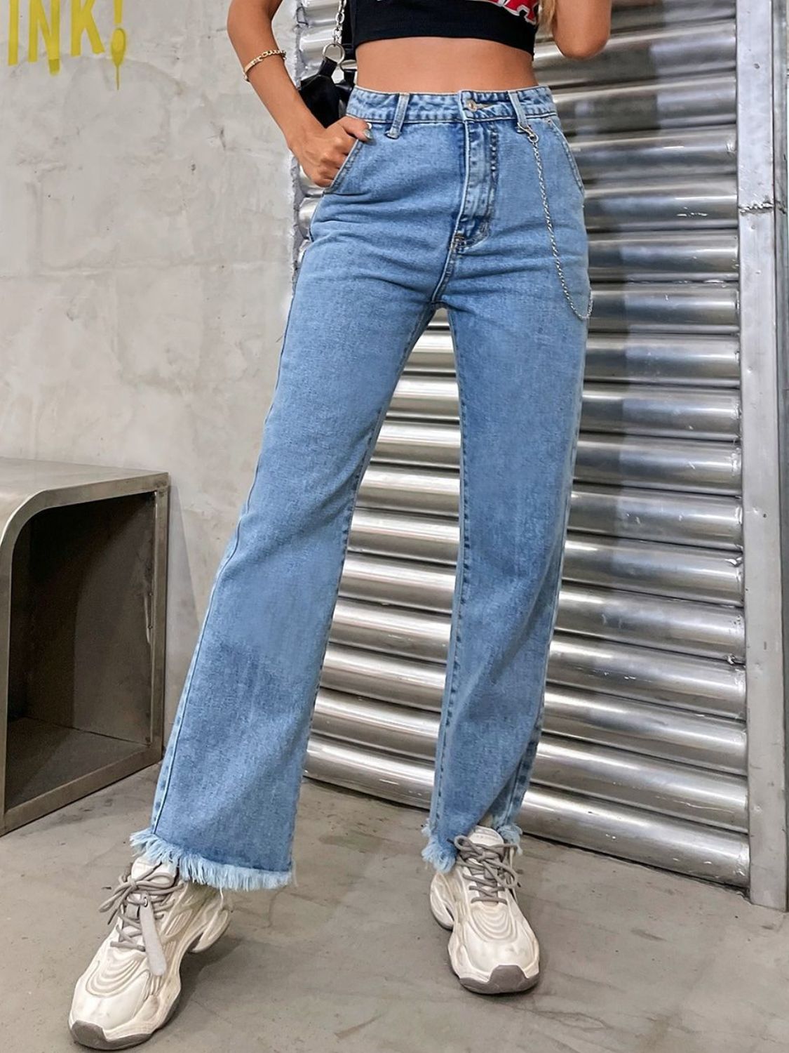 Light wash denim jeans with chain detail and frayed hem