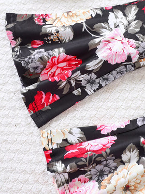Flared floral pants and top set in black with vibrant red, pink, and white flowers.
