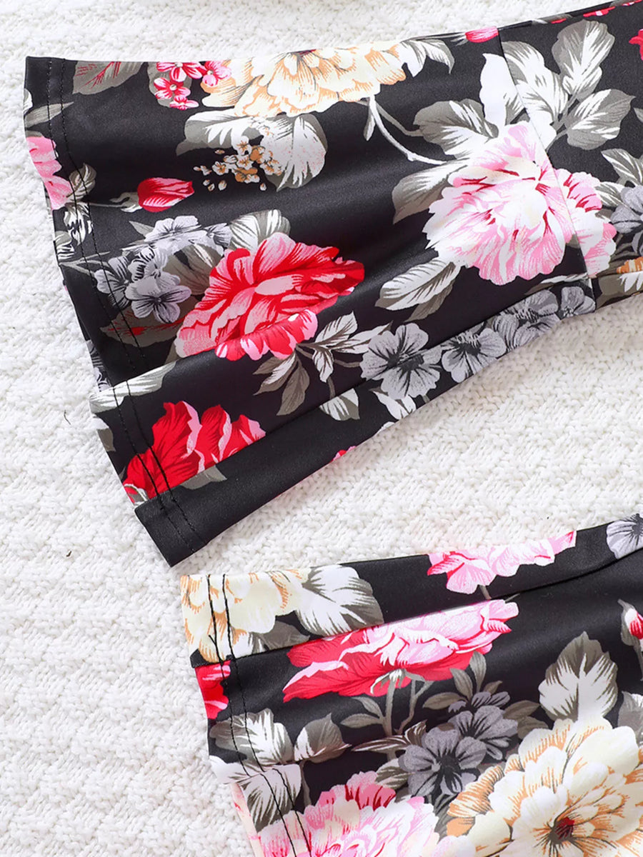 Flared floral pants and top set in black with vibrant red, pink, and white flowers.