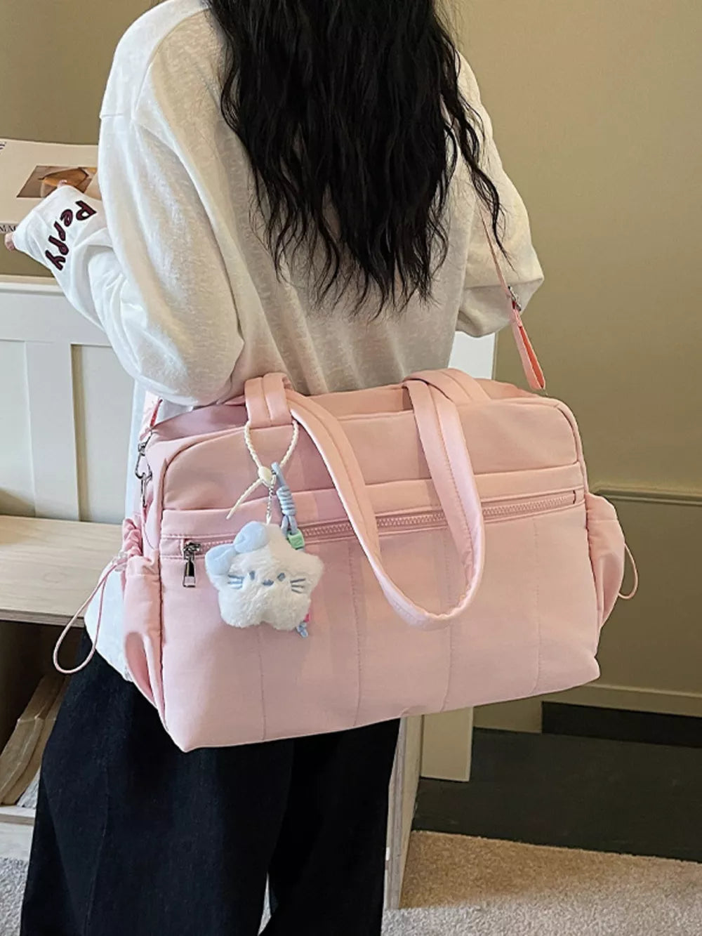 Pink quilted tote bag with zipper pockets and a fluffy star charm
