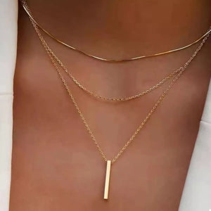 Gold layered bar pendant necklace with delicate chains.