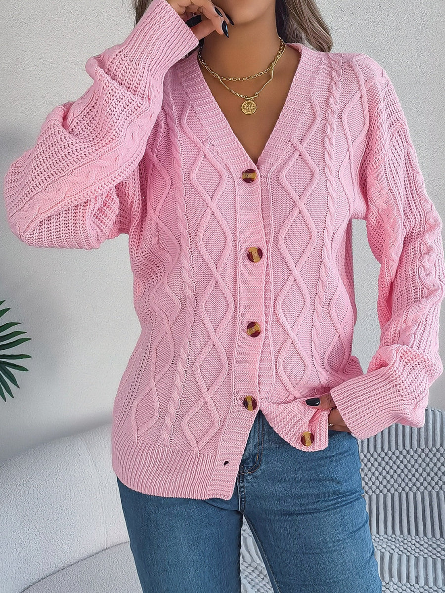 Blush pink cable knit balloon sleeve cardigan with button front and v-neck.