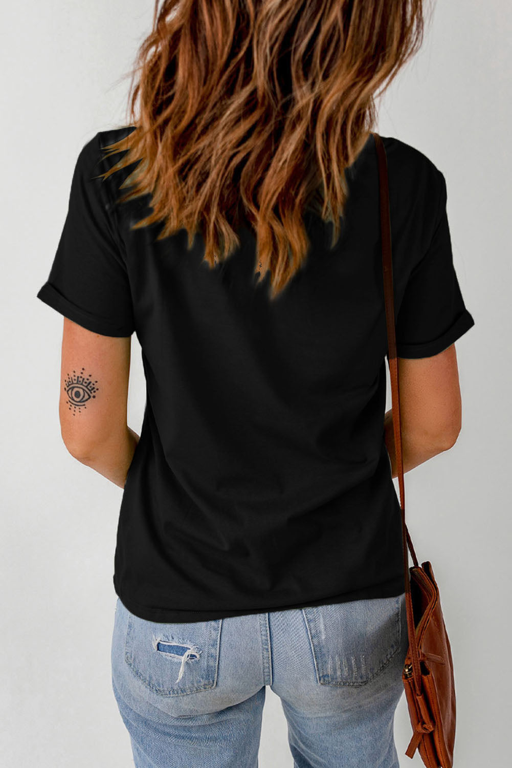 Black t-shirt with rolled sleeves and a graphic print on the left arm.