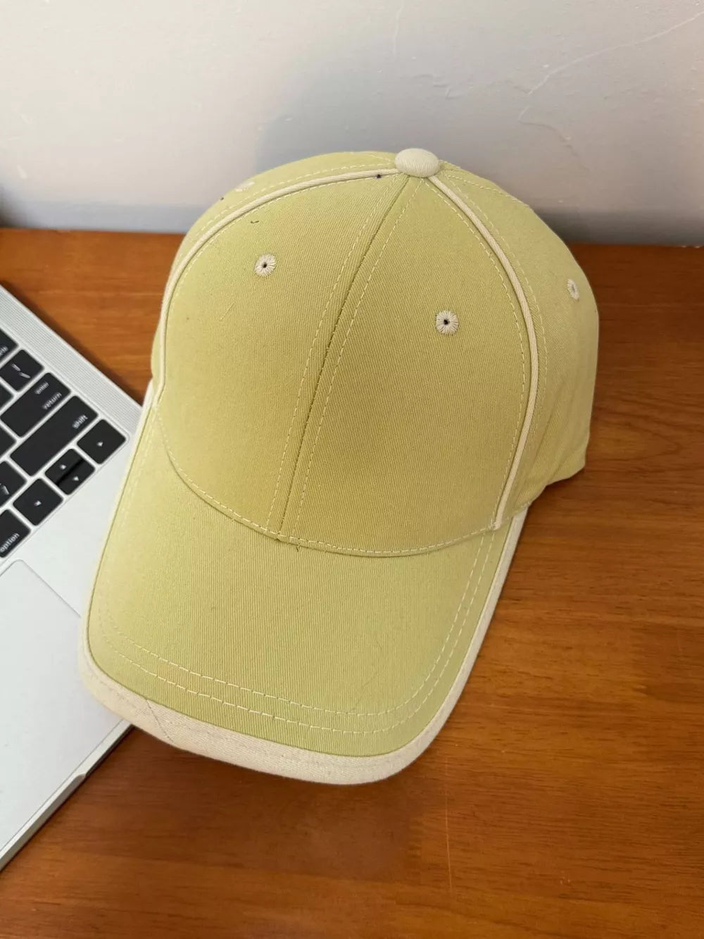 Yellow cotton baseball cap with contrast stitching and cream white brim detail.