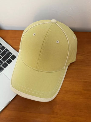 Yellow cotton baseball cap with contrast stitching and cream white brim detail.