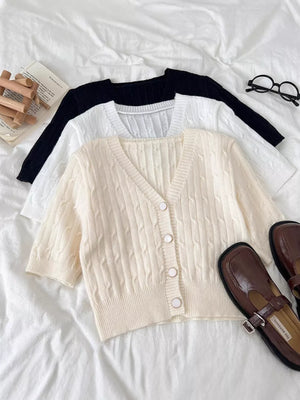 Chic cable-knit cropped cardigan in apricot with button front and V-neck.