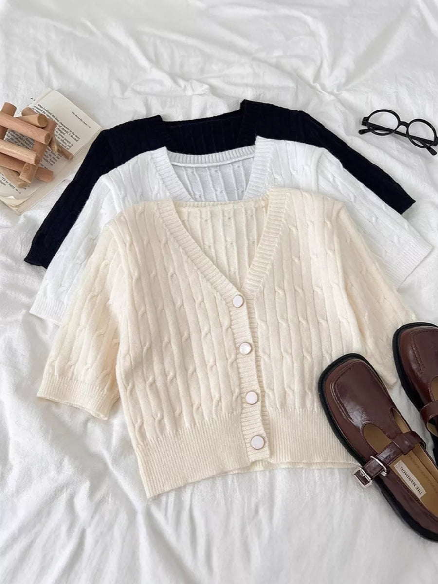Chic cable-knit cropped cardigan in apricot with button front and V-neck.