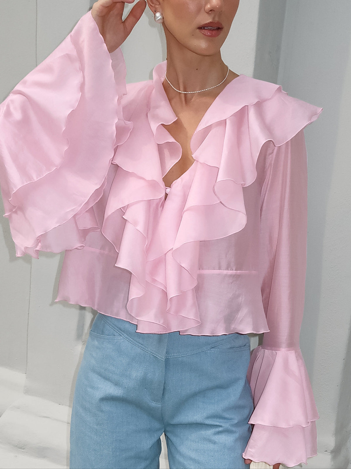 Pink ruffle trim long sleeve blouse with dramatic sleeves and a V-neck.