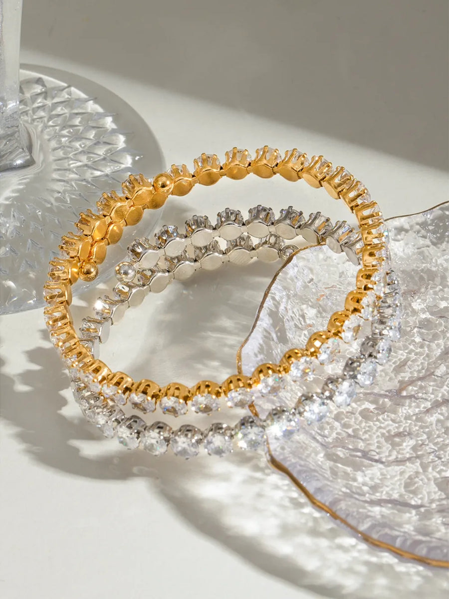 Double row pavé bangle bracelet in gold and silver with clear stones.