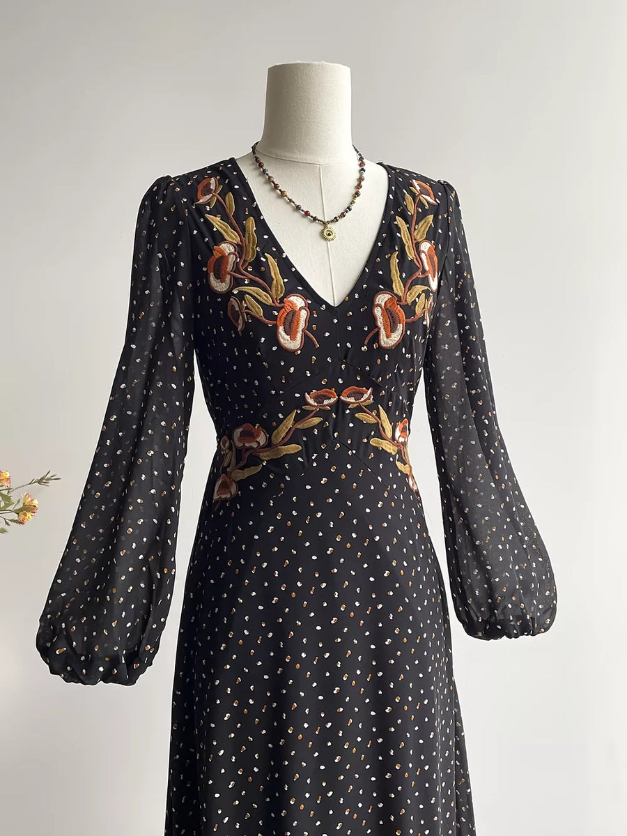 Black floral embroidered maxi dress with V-neck, long puff sleeves, and polka dot print.